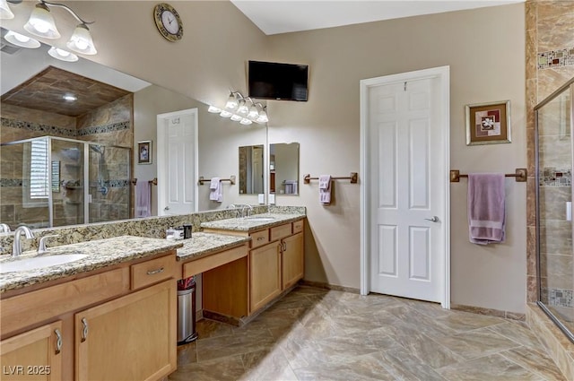 bathroom featuring a sink, double vanity, marble finish floor, baseboards, and a stall shower