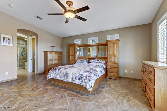 bedroom featuring arched walkways, baseboards, lofted ceiling, and visible vents
