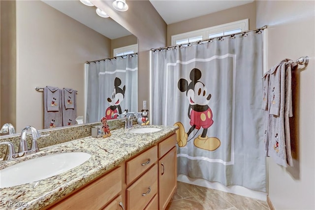 bathroom featuring a sink, a shower with curtain, and double vanity