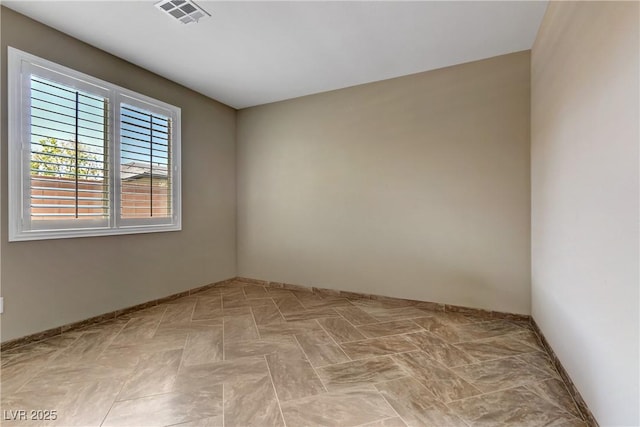 unfurnished room with baseboards and visible vents
