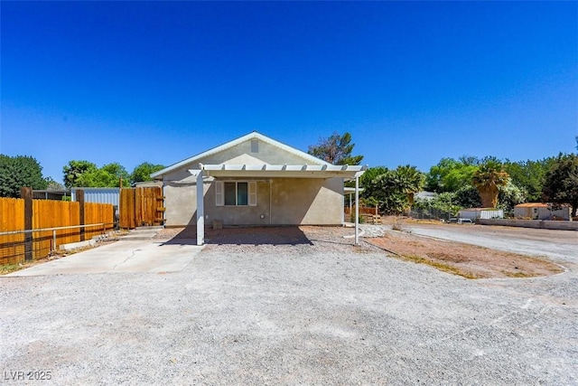 bungalow-style house featuring fence and stucco siding