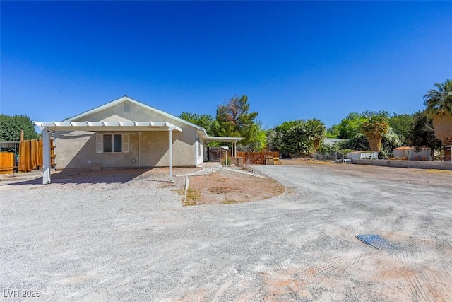 view of front of home featuring fence and stucco siding