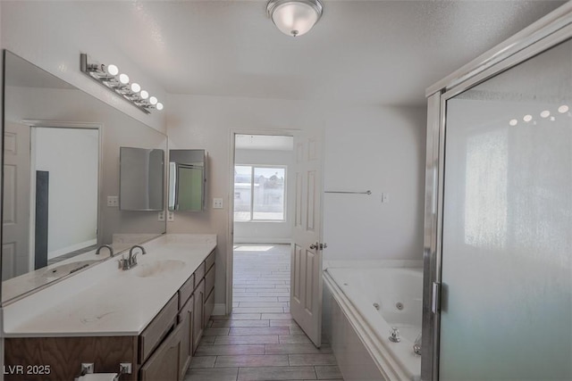 bathroom featuring a jetted tub, vanity, and wood finish floors