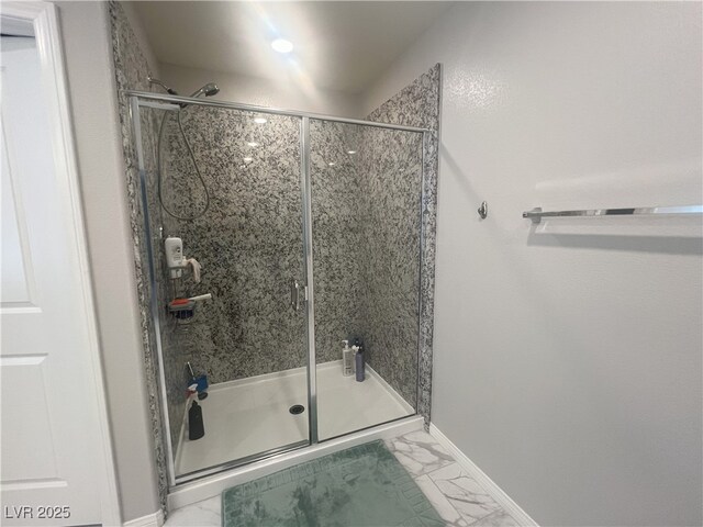 7527 Ardenno St, North Las Vegas, NV 89084 - bathroom with marble look tiles, a shower stall, and baseboards