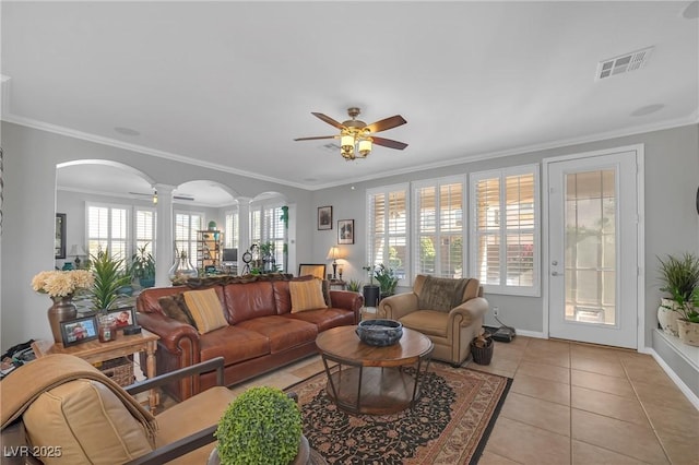 living room with visible vents, decorative columns, light tile patterned flooring, arched walkways, and a ceiling fan