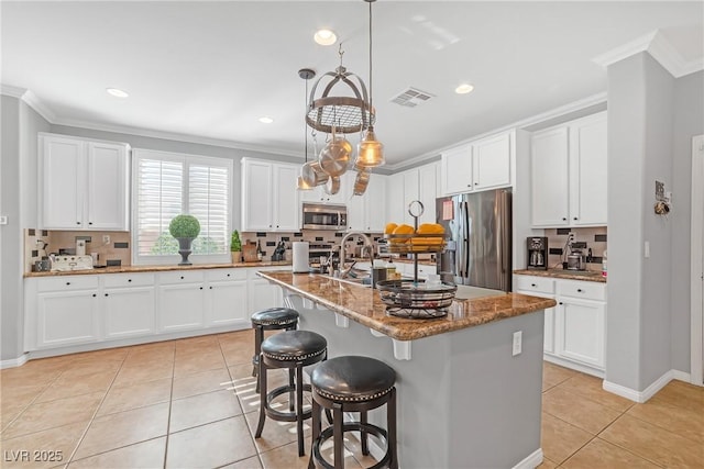 kitchen with visible vents, crown molding, light tile patterned floors, and stainless steel appliances