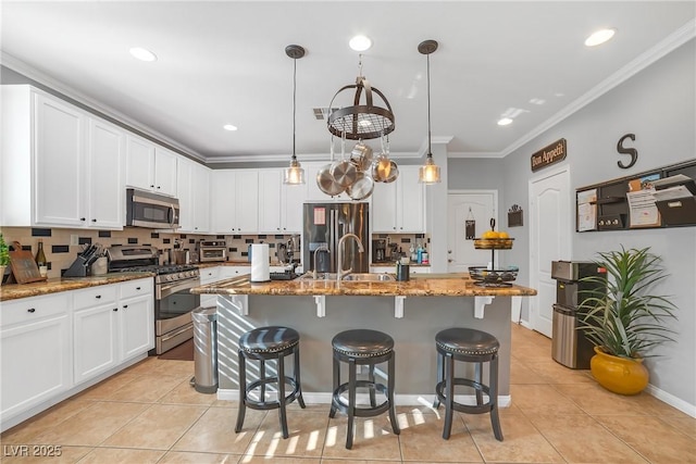 kitchen featuring appliances with stainless steel finishes, light stone countertops, white cabinets, a breakfast bar, and light tile patterned flooring
