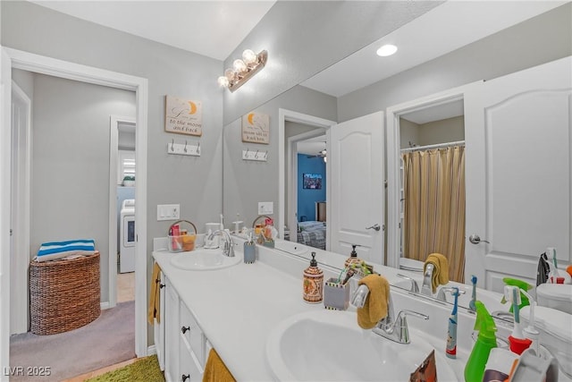 full bathroom with double vanity, a sink, washer / dryer, and a shower with shower curtain