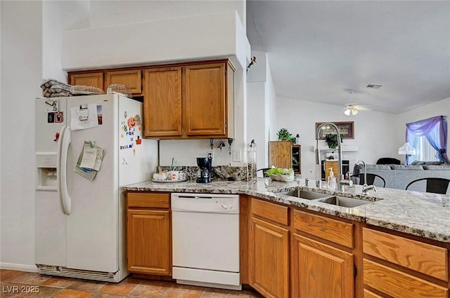 7874 Trail Boss Ct, Las Vegas, NV 89113 - kitchen featuring white appliances, brown cabinets, light stone countertops, ceiling fan, and vaulted ceiling