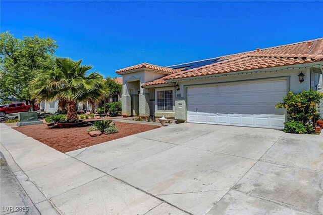 7874 Trail Boss Ct, Las Vegas, NV 89113 - mediterranean / spanish-style house featuring driveway, a tiled roof, solar panels, and a garage