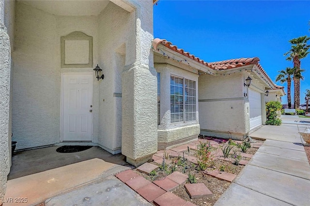 7874 Trail Boss Ct, Las Vegas, NV 89113 - entrance to property featuring a tile roof, stucco siding, and a garage