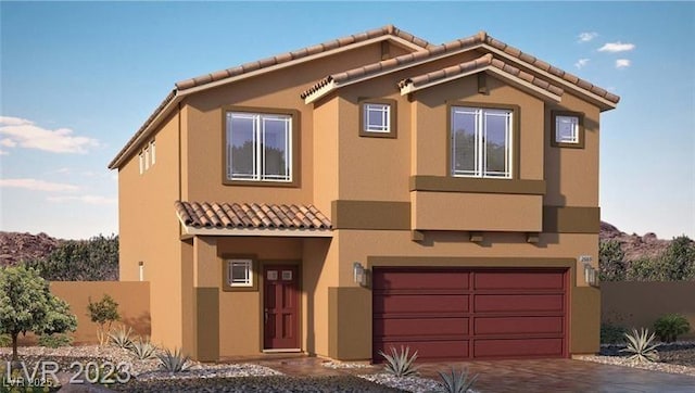 view of front of house with stucco siding, driveway, a tile roof, and a garage