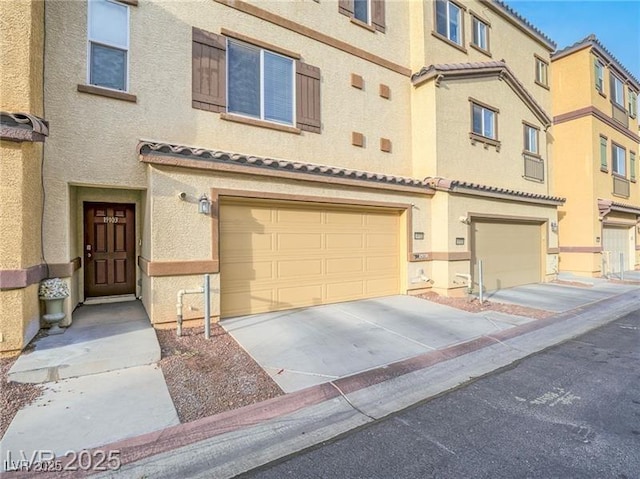 1525 Spiced Wine Ave Unit 19103, Henderson, NV 89074 - view of front of house with a tiled roof, an attached garage, driveway, and stucco siding