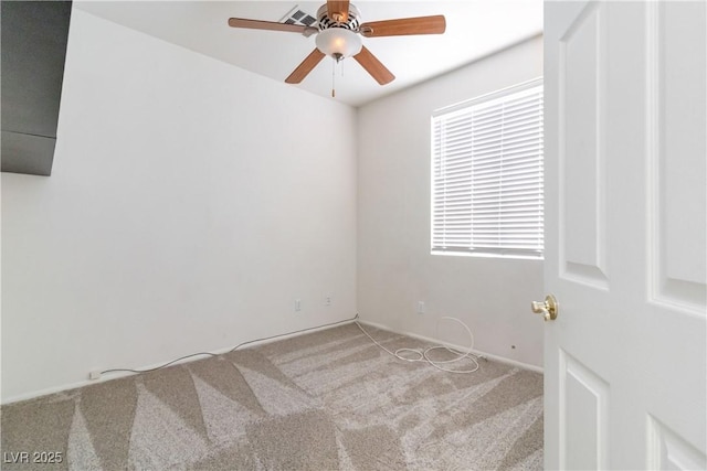 carpeted spare room featuring plenty of natural light and a ceiling fan