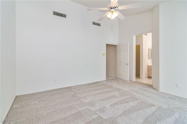 spare room with visible vents, a ceiling fan, and light colored carpet