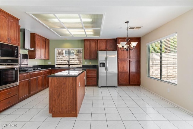 kitchen featuring dark countertops, a chandelier, stainless steel appliances, a healthy amount of sunlight, and visible vents