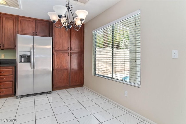 kitchen featuring dark countertops, a chandelier, baseboards, stainless steel refrigerator with ice dispenser, and visible vents