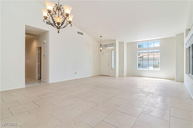unfurnished room with a chandelier, visible vents, light tile patterned floors, and lofted ceiling