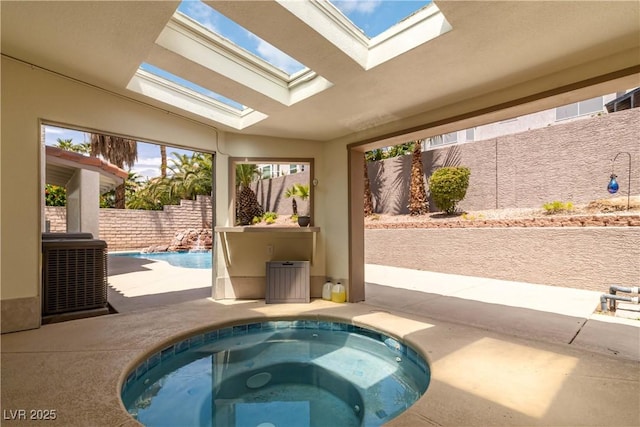 view of swimming pool featuring a fenced backyard, a patio, an in ground hot tub, and central AC