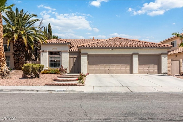 mediterranean / spanish home featuring a tiled roof, an attached garage, driveway, and stucco siding