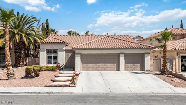 mediterranean / spanish-style home with fence, an attached garage, stucco siding, concrete driveway, and a tiled roof
