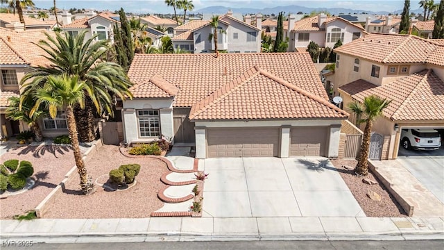 mediterranean / spanish home featuring driveway, a residential view, a tile roof, and a garage