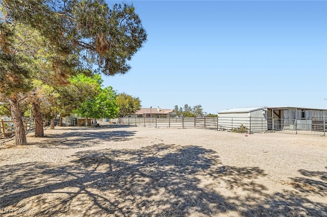 view of yard featuring an exterior structure, fence, and an outdoor structure