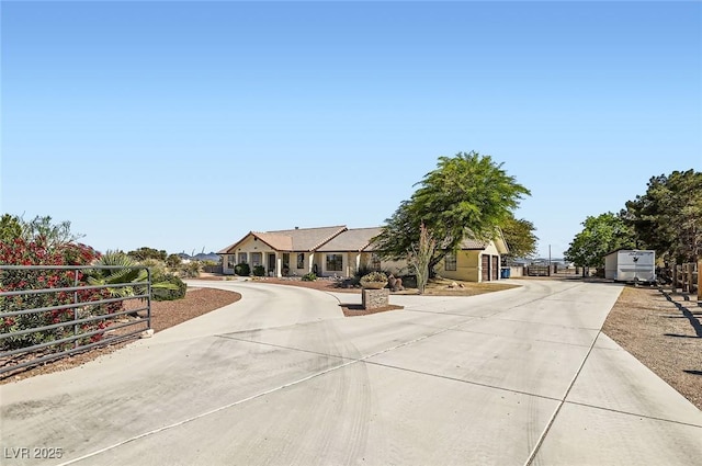view of front of property featuring curved driveway and fence