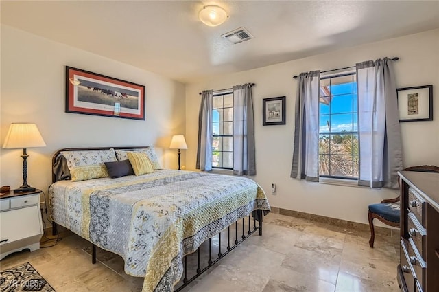 bedroom with visible vents, baseboards, and multiple windows