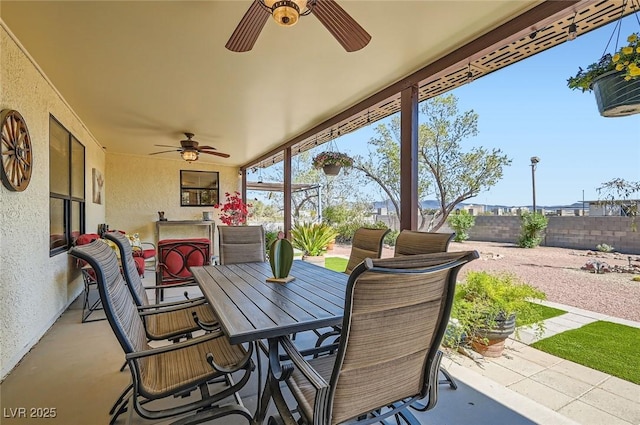 view of patio with outdoor dining area, a ceiling fan, and a fenced backyard