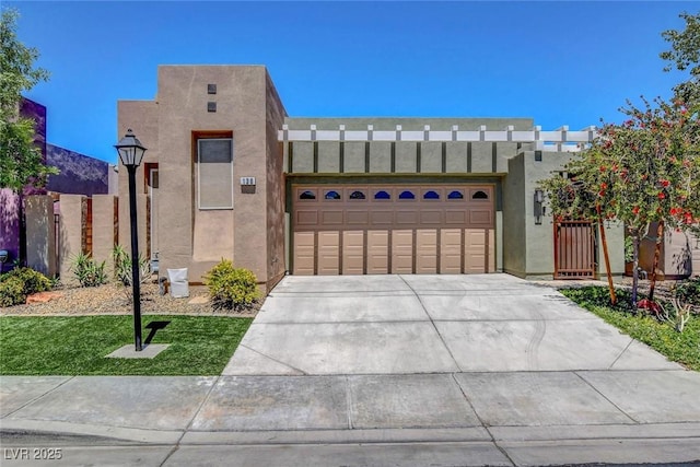 adobe home with an attached garage, stucco siding, and driveway