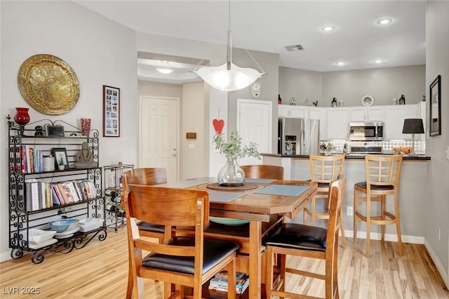 dining space with recessed lighting, baseboards, visible vents, and light wood-style floors