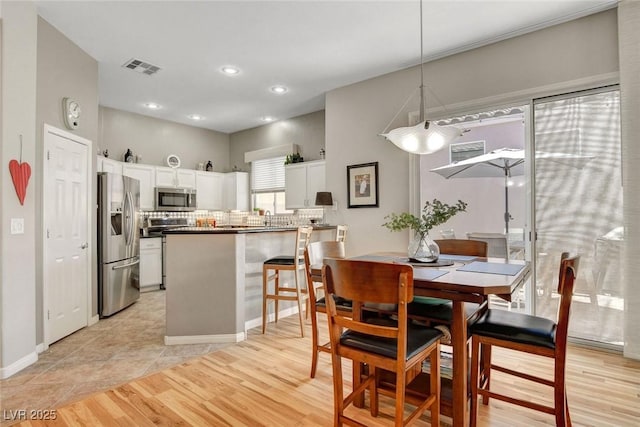 dining space with recessed lighting, light wood-style flooring, and visible vents
