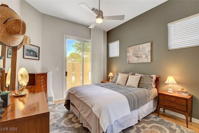 bedroom featuring ceiling fan, visible vents, wood finished floors, baseboards, and access to outside