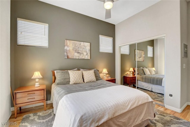 bedroom featuring a closet, a ceiling fan, light wood finished floors, and baseboards
