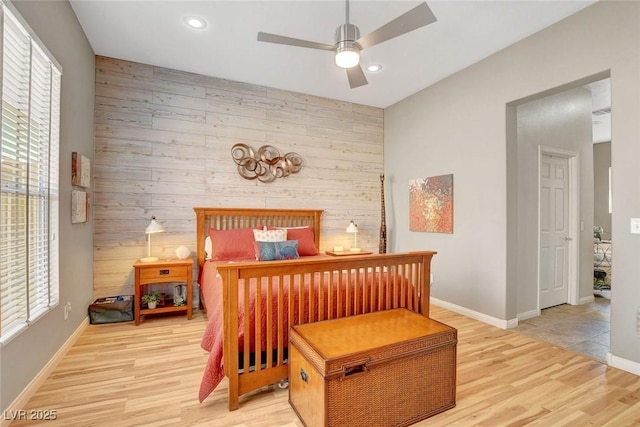 bedroom with wood walls, baseboards, ceiling fan, light wood-type flooring, and recessed lighting