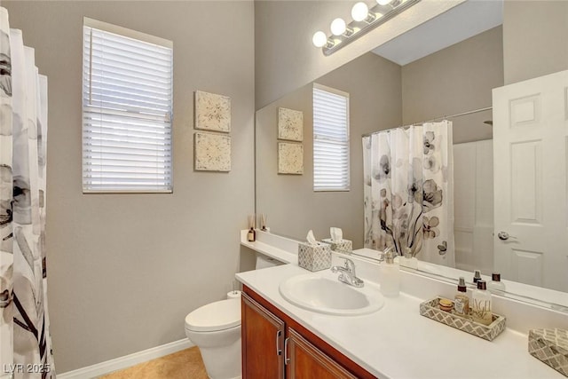 bathroom featuring tile patterned flooring, curtained shower, vanity, baseboards, and toilet