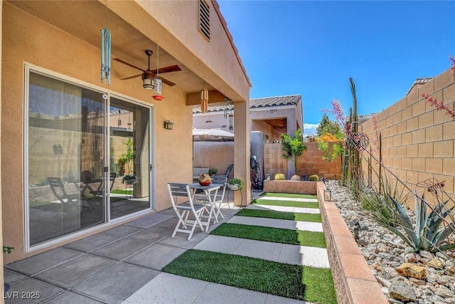 view of yard with a fenced backyard, a ceiling fan, and a patio
