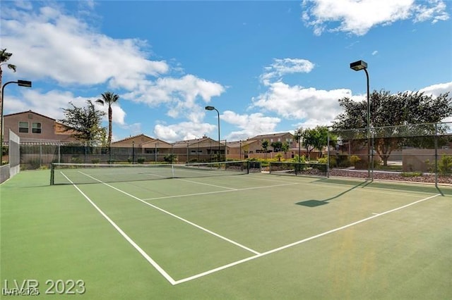 view of tennis court featuring fence