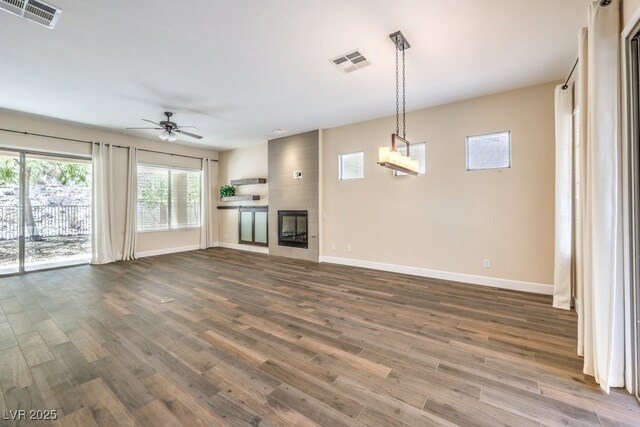 35 Glade Water Dr, Henderson, NV 89052 - unfurnished living room with baseboards, ceiling fan, wood finished floors, and a fireplace