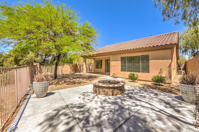 35 Glade Water Dr, Henderson, NV 89052 - back of property with a tile roof, an outdoor fire pit, stucco siding, a patio, and a fenced backyard