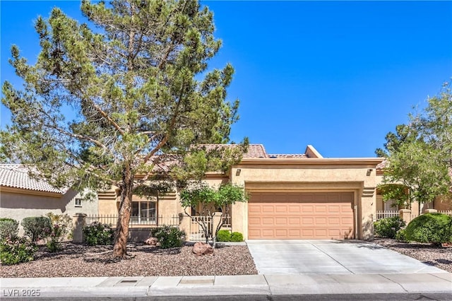 view of front of house with fence, an attached garage, driveway, and stucco siding