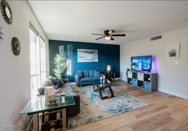 3789 Heritage Ave, Las Vegas, NV 89121 - living room with wood finished floors, ceiling fan, baseboards, and an accent wall