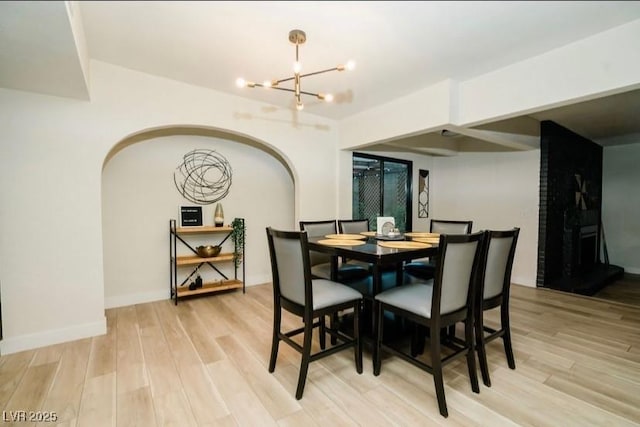 3789 Heritage Ave, Las Vegas, NV 89121 - dining area with a chandelier, wood finished floors, and arched walkways