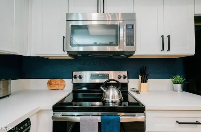3789 Heritage Ave, Las Vegas, NV 89121 - kitchen with stainless steel appliances, white cabinetry, light countertops, and decorative backsplash