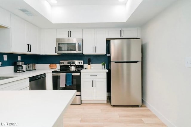 3789 Heritage Ave, Las Vegas, NV 89121 - kitchen featuring appliances with stainless steel finishes, a tray ceiling, white cabinetry, and recessed lighting