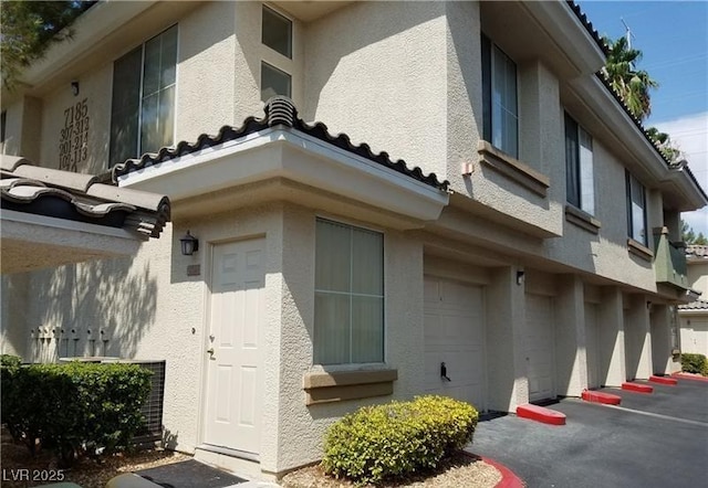 view of home's exterior with an attached garage and stucco siding