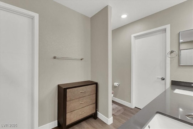 full bathroom featuring baseboards, vanity, toilet, and wood finished floors