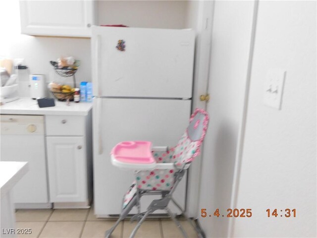 kitchen with light countertops, white cabinetry, light tile patterned floors, and white appliances