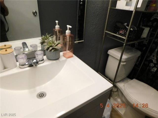 bathroom featuring toilet and vanity